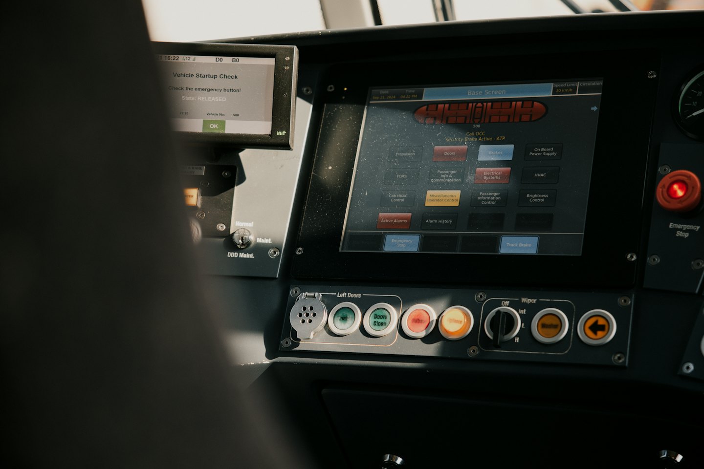 Modern vehicle cockpit panel with digital screens and operational buttons.